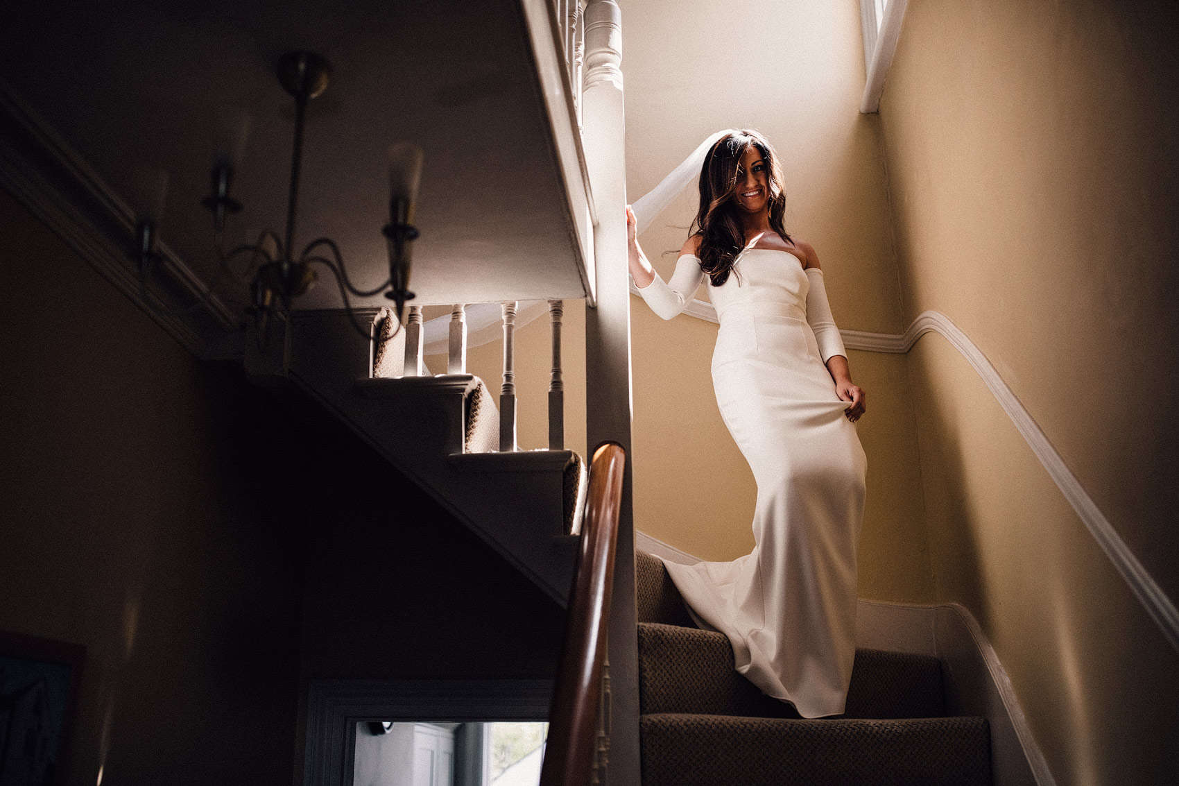 bride walking down stairs in wedding dress