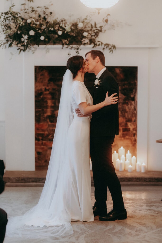 first kiss at candle lit wedding at Aswarby Rectory in Sleaford