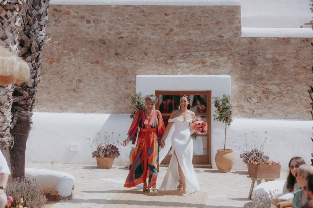 Mother walking daughter down aisle at wedding in Ibiza